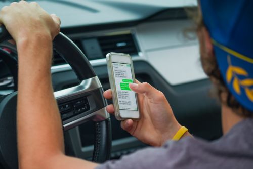 Young Man Texting While Driving - Hampton & Royce, L.C.