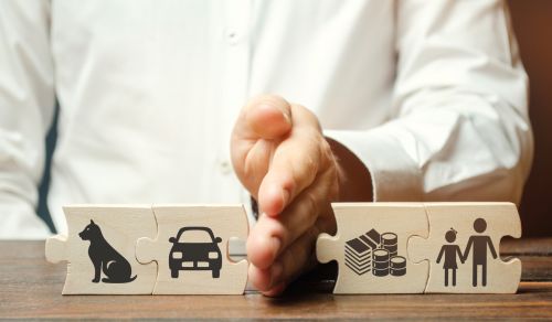 A man splits wooden puzzles with images of property, children and pets. - Hampton & Royce, L.C.